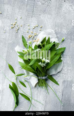 Photo studio de feuilles de ramson fraîches et de pignons couchés sur une surface en bois Banque D'Images