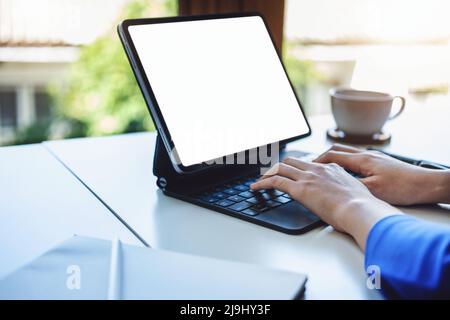 Une femme d'affaires utilisant une tablette blanche vierge avec une calculatrice pour calculer des documents de budget sur son bureau Banque D'Images