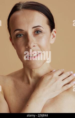 Portrait d'une femme moderne posant sur fond beige. Banque D'Images