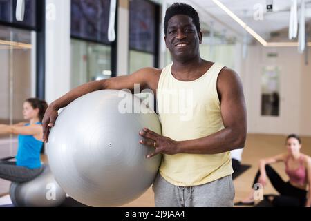Instructeur de pilates afro-américains debout avec le fitball Banque D'Images