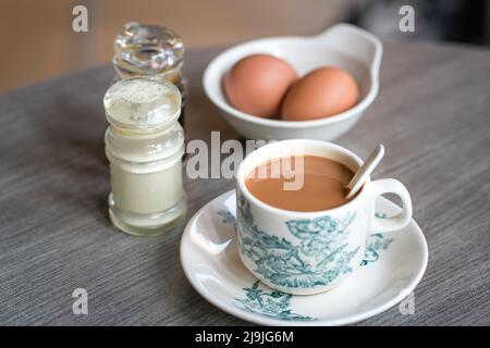 Café avec œufs durs, sauce soja et poivre blanc sur la table. Petit-déjeuner traditionnel de style kopitiam chinois oriental. Banque D'Images