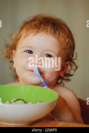 Cutr bébé enfant se mangeant avec une cuillère. Banque D'Images