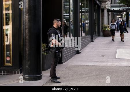 Seattle, États-Unis. 23nd mai 2022. Un agent de sécurité armé privé sur 2nd et Pike. Les entreprises se tournent vers la sécurité privée armée et non armée dans le quartier commerçant de Westlake après une augmentation du vol et de la criminalité violente dans le centre-ville. La police de Seattle a mis en place un poste de police mobile en mars près du bâtiment Amazon Ivy le 3rd et Pine après que le géant de la technologie a fait la une des journaux en informant les employés travaillant dans le bâtiment Ivy, Ils peuvent choisir un autre endroit où s'exercer jusqu'à ce que la police prenne le contrôle du crime dans le couloir de Pike et Pine. James Anderson/Alay Live News Banque D'Images