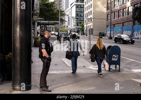 Seattle, États-Unis. 23nd mai 2022. Un agent de sécurité armé privé sur 2nd et Pike. Les entreprises se tournent vers la sécurité privée armée et non armée dans le quartier commerçant de Westlake après une augmentation du vol et de la criminalité violente dans le centre-ville. La police de Seattle a mis en place un poste de police mobile en mars près du bâtiment Amazon Ivy le 3rd et Pine après que le géant de la technologie a fait la une des journaux en informant les employés travaillant dans le bâtiment Ivy, Ils peuvent choisir un autre endroit où s'exercer jusqu'à ce que la police prenne le contrôle du crime dans le couloir de Pike et Pine. James Anderson/Alay Live News Banque D'Images