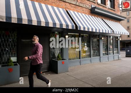 Seattle, États-Unis. 23nd mai 2022. Une personne passant par les vêtements Fjallraven sur 1nd et Pine. Les entreprises ont installé des portes coulissantes et du verre anti-chocs balistique dans le quartier commercial de Westlake après une augmentation du vol et des crimes violents dans le centre-ville. La police de Seattle a mis en place un poste de police mobile en mars près du bâtiment Amazon Ivy le 3rd et Pine après que le géant de la technologie a fait la une des journaux en informant les employés travaillant dans le bâtiment Ivy, Ils peuvent choisir un autre endroit où s'exercer jusqu'à ce que la police prenne le contrôle du crime dans le couloir de Pike et Pine. James Anderson/Alay Live News Banque D'Images