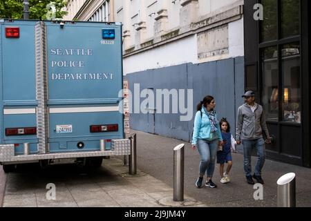 Seattle, États-Unis. 23nd mai 2022. Une famille passant le terminal mobile de la police de Seattle par le bâtiment Amazon Ivy sur 3rd et Pine. SPD a établi une présence à temps plein dans la région après que le géant de la technologie a fait les gros titres en disant aux employés travaillant dans le bâtiment Ivy, ils peuvent choisir un autre emplacement Amazon pour travailler jusqu'à ce que la police prenne le contrôle de la criminalité dans le couloir Pike and Pine. Cela a suivi plusieurs fusillades sur 3rd et Pine. James Anderson/Alay Live News Banque D'Images