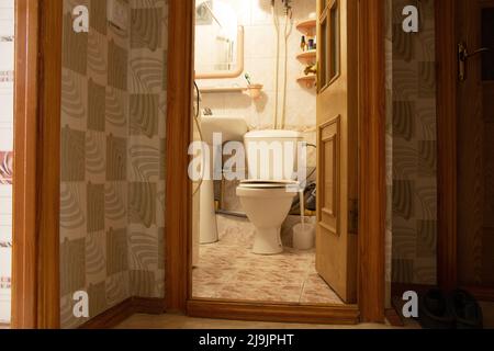 Salle de bains, cuvette de toilette dans les toilettes dans un appartement résidentiel avec une porte ouverte à la salle de bains, toilettes dans l'appartement Banque D'Images