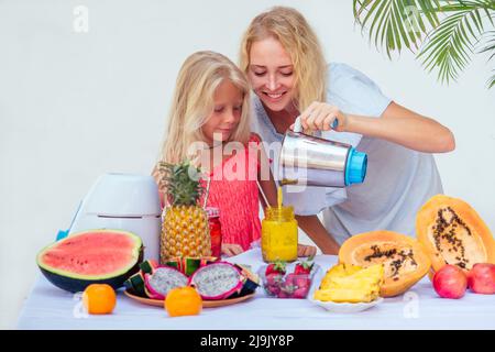 Bonne mère blonde et sa fille aiment faire et boire des smoothies ensemble à Bali. famille caucasienne dans l'été ropique vacances boire Banque D'Images