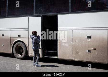 Bakhmut, Ukraine. 23rd mai 2022. Une femme fume devant un bus d'évacuation d'urgence. La région du Donetsk (Donbass) est en butte à de lourdes attaques, alors que les forces russes et ukrainiennes s'y disputent, au milieu de l'invasion russe complète de l'Ukraine commencée le 24 février, la guerre qui a tué de nombreux civils et soldats. Crédit : SOPA Images Limited/Alamy Live News Banque D'Images