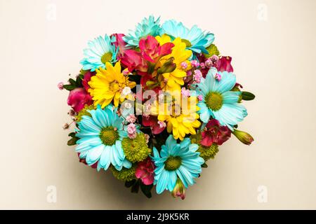 Bouquet délicat de chrysanthèmes jaunes et bleus sur une table blanche, vue du dessus Banque D'Images