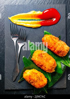 Vue sur une assiette de croquettes de hors-d'œuvre servie dans un style gastronomique. Croquettes espagnoles traditionnelles faites maison. Banque D'Images