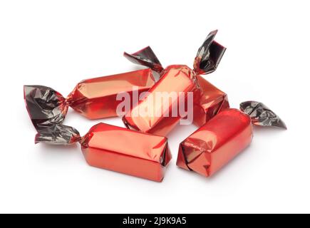 Groupe de bonbons au chocolat enveloppés dans des emballages rouges isolés sur du blanc Banque D'Images