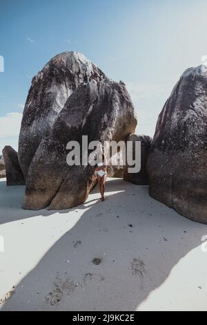 Jeune femme asiatique brun se tenant à côté de rochers géants sur une plage de sable blanc de l'île tropicale à Belitung Indonésie Banque D'Images