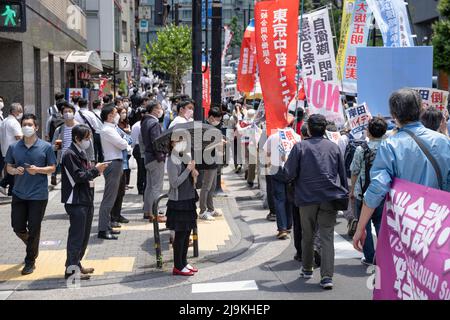 Tokyo, Japon. 24th mai 2022. Les spectateurs regardent des manifestants qui scandaient des slogans anti-gouvernementaux et exigeaient le « concassage » du Japon, de l'Australie, de l'Inde et des États-Unis (Quad) Réunion des dirigeants 2022. Un petit groupe d'environ 100 manifestants se sont rassemblés dans le centre de Tokyo pour protester contre la Réunion des dirigeants du Quad 2022 et pour exprimer leur opinion sur la guerre en cours en Ukraine critiquant la Russie, les États-Unis et l'OTAN. Ils ont également appelé le Premier ministre japonais Fumio Kishida à démissionner ainsi que le président américain Joe Biden. Crédit : SOPA Images Limited/Alamy Live News Banque D'Images