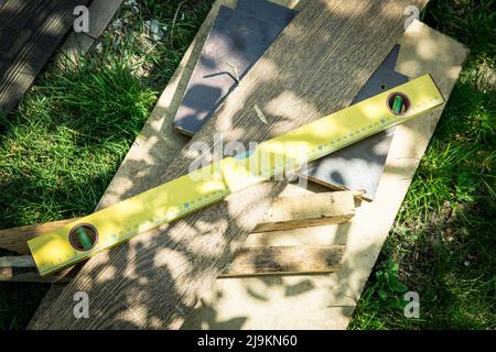 Un ensemble d'outils de menuiserie repose sur l'herbe. Niveau, anciennes cartes. Banque D'Images