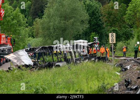 Blaustein, Allemagne. 24th mai 2022. Les secouristes sont à côté d'un bus brûlé. Ce bus s'est arrêté sur un passage à niveau pendant un embouteillage et a été frappé par un train. Le bus a brûlé, de nombreuses personnes ont été blessées. (À dpa 'train collides avec bus près d'Ulm - plusieurs blessés') Credit: Stefan Puchner/dpa/Alamy Live News Banque D'Images