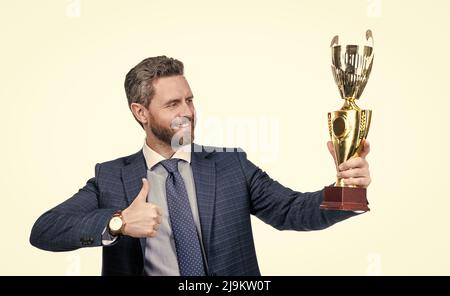 Récompense pour le travail.Le pdg heureux montre les pouces jusqu'à la coupe d'or.Récompense et reconnaissance Banque D'Images