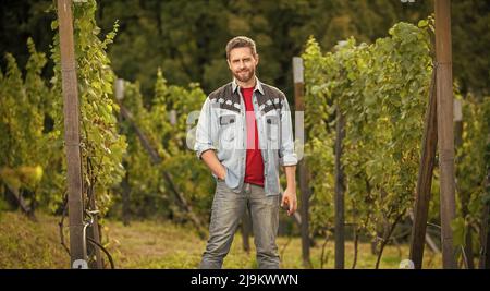 homme souriant debout avec des ciseaux de jardin à la cave de vinification, récolte d'été Banque D'Images