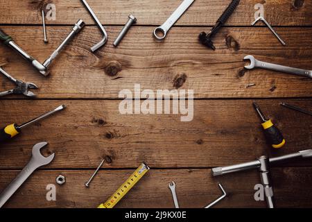 Poser à plat avec divers outils de travail sur une table de travail en bois. Vue de dessus du nouveau jeu d'outils manuels pour la réparation, du kit de construction, du pavillon. Indispensable pour les hommes. Équipement de construction. Concept de l'industrie Banque D'Images