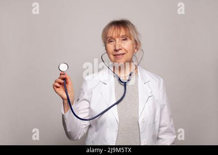 Médecin positif de femme d'âge moyen avec stéthoscope Banque D'Images