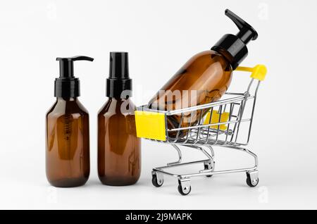 Flacons cosmétiques avec distributeurs sur fond blanc. Bouteille cosmétique dans un panier. Produits DE SPA Banque D'Images