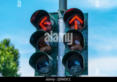 feu de circulation avec deux flèches rouges indiquant l'arrêt pour la direction vers la gauche et tout droit Banque D'Images