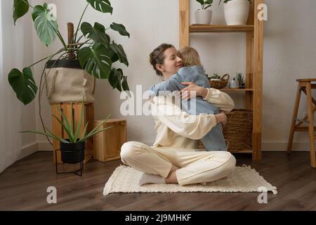 Crochez une femme adulte avec des cheveux ondulés en buvant un café savoureux tout en regardant vers l'avant dans la maison Banque D'Images