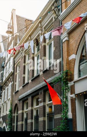 Faible angle de linge suspendu sur la corde à linge au-dessus de la rue près des bâtiments traditionnels en brique à Amsterdam en journée Banque D'Images