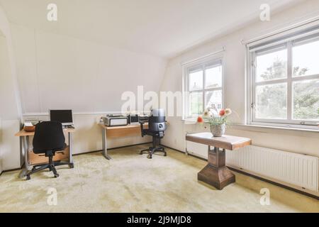 Bureau avec ordinateur et chaise dans un espace de travail léger en journée dans un appartement moderne Banque D'Images