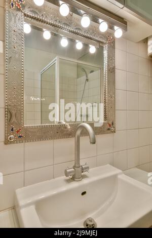 Lavabo et armoires avec miroir placés dans un mur de carrelage dans la salle de bains Banque D'Images