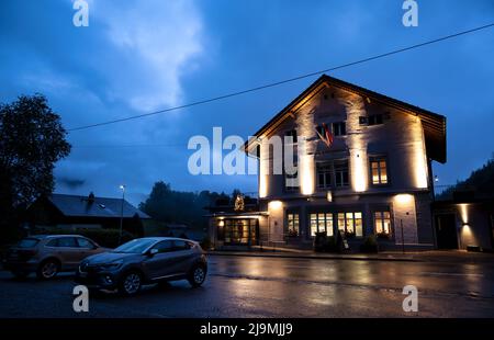 Vue heure bleue du restaurant en bois illuminé situé dans le village alpin de Hasliberg, Suisse. Banque D'Images