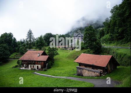Vue d'une belle maison de chalet alpin en bois avec un beau jardin coloré et une clôture capturée à Aareschlucht, Suisse. Banque D'Images