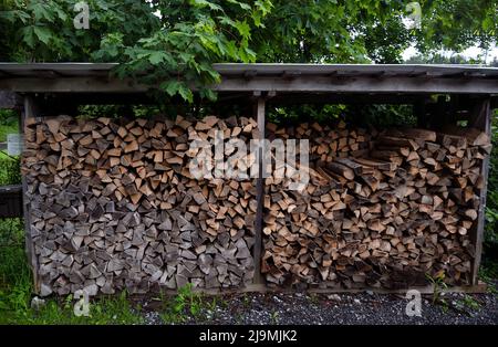 Grosses grumes de bois produit de l'industrie du bois, la foresterie empilées pour le stockage dans une maison de ferme dans le village de campagne de Schattenhalb, en Suisse Banque D'Images