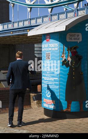 Homme achetant un billet de bateau à l'aide d'un téléphone portable distributeur automatique Tower Bridge Londres Banque D'Images