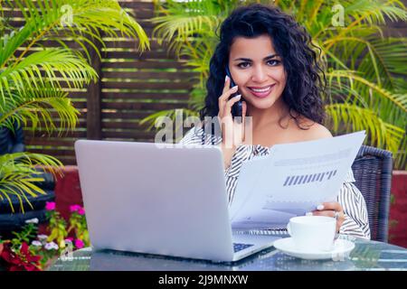 Femme afro-américaine avec téléphone et ordinateur portable dans un cafe.indian Business dame freelance surfant à distance travail Banque D'Images