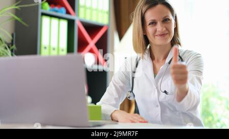 Sourire un médecin confiant et approbaissant les pouces Banque D'Images