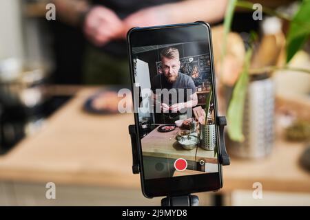 Mise au point horizontale sélective gros plan de Food Blogger filmant du contenu sur l'appareil photo de smartphone à l'aide d'un trépied Banque D'Images