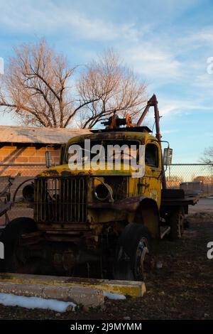 Ancien et ancien camion de grue jaune dans une ville abandonnée sous le ciel bleu Banque D'Images