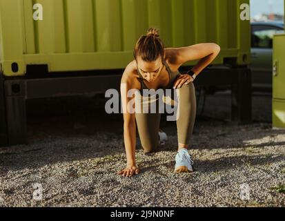 Jolie jeune femme en sport s'exerçant dans un environnement urbain Banque D'Images