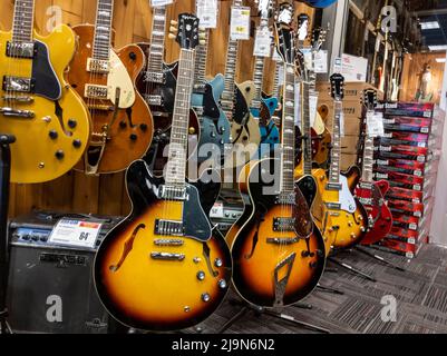 Lynnwood, WA USA - vers mai 2022: Vue de divers guitares électriques à vendre dans un magasin d'instruments de musique Guitar Center. Banque D'Images