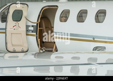 Escaliers et porte d'un petit jet privé dans hangar prêt à voler - photo de stock Banque D'Images