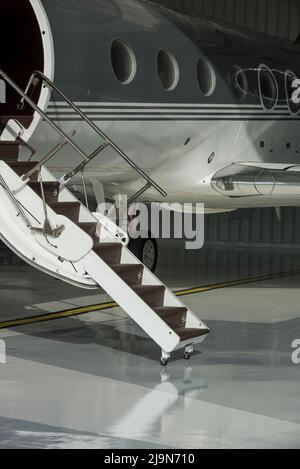 Escalier et porte jet privé dans hangar prêt à voler - photo de stock Banque D'Images