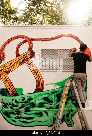 Homme peint une murale graffiti dans Lower East Side Manhattan, New York Banque D'Images