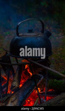 une vieille bouilloire de camping est chauffée sur un feu Banque D'Images