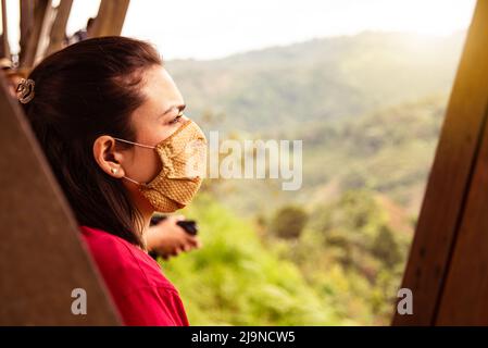 femme avec masque médical en point de vue observant les montagnes de paysage en amérique latine Banque D'Images