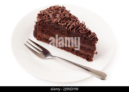 Tranche de gâteau au chocolat avec garniture à la crème et copeaux de chocolat à côté de la fourchette sur la plaque blanche isolée sur le blanc. Banque D'Images