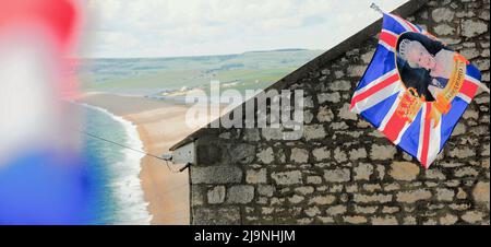 Île de Portland. 24th mai 2022. Météo Royaume-Uni. Le drapeau du Jubilé de platine de la Reine flotte sous le soleil chaud, au-dessus de la plage de Chesil, sur l'île de Portland. Crédit : stuart fretwell/Alay Live News Banque D'Images