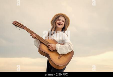 enfant fille élégante jouant de la guitare en plein air, vocal Banque D'Images