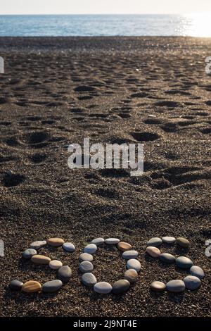 SOS signifie sauver nos âmes message fait avec des pierres sur la plage Banque D'Images