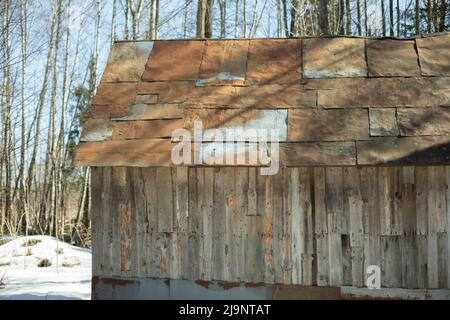 Toit rouillé de la maison en bois. Ancien toit de la maison. Tissus d'ameublement en métal et paroi en planche. Refuge forestier. Banque D'Images